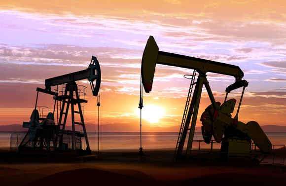 Two pumpjacks in operation at sunset. 