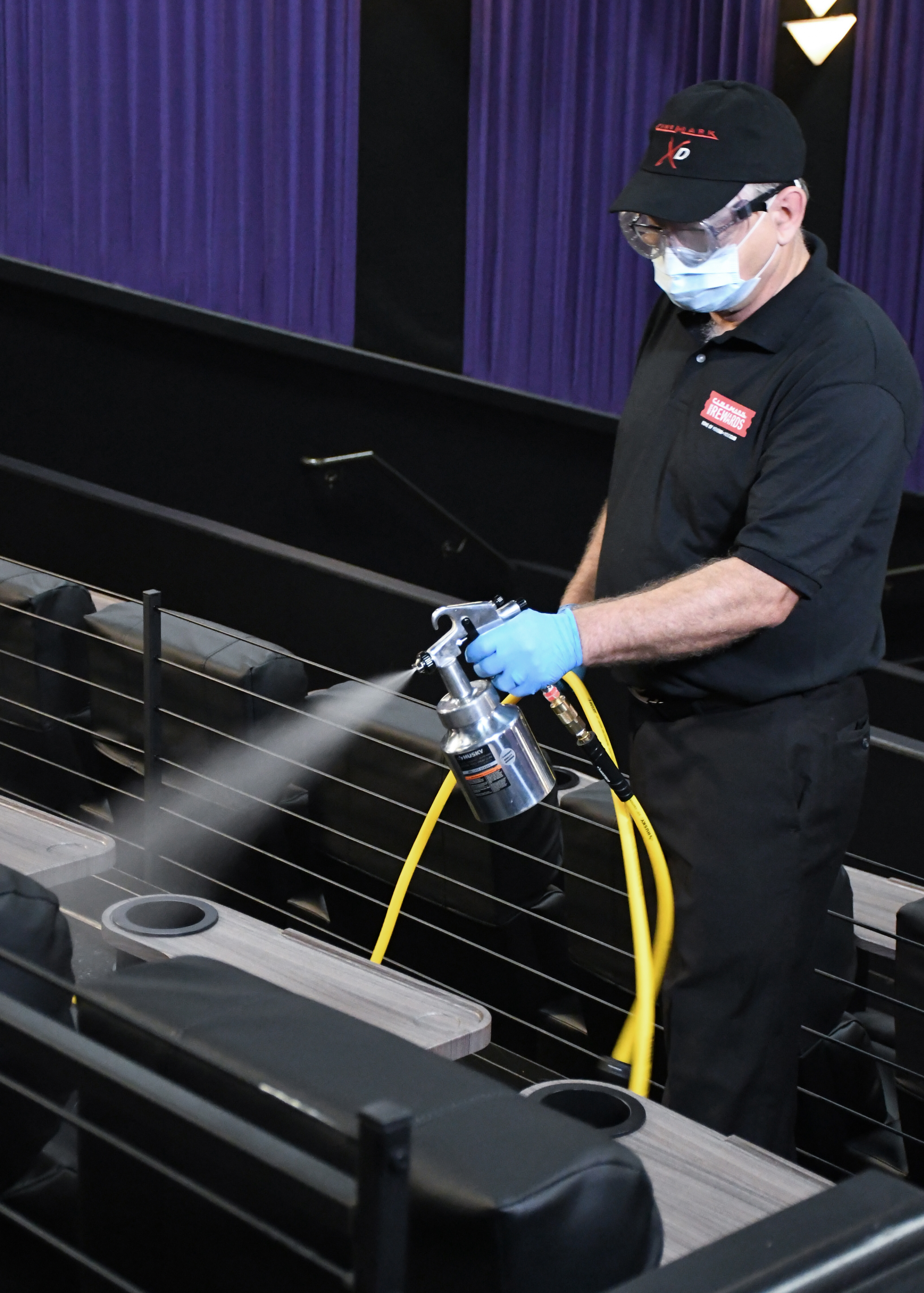 Cinemark worker sprays sanitizer on movie seats