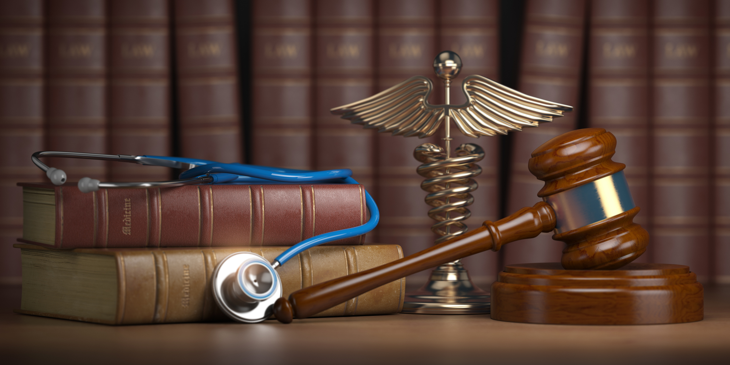 Stethescope and gavel on desk with caduceus ornament and books.