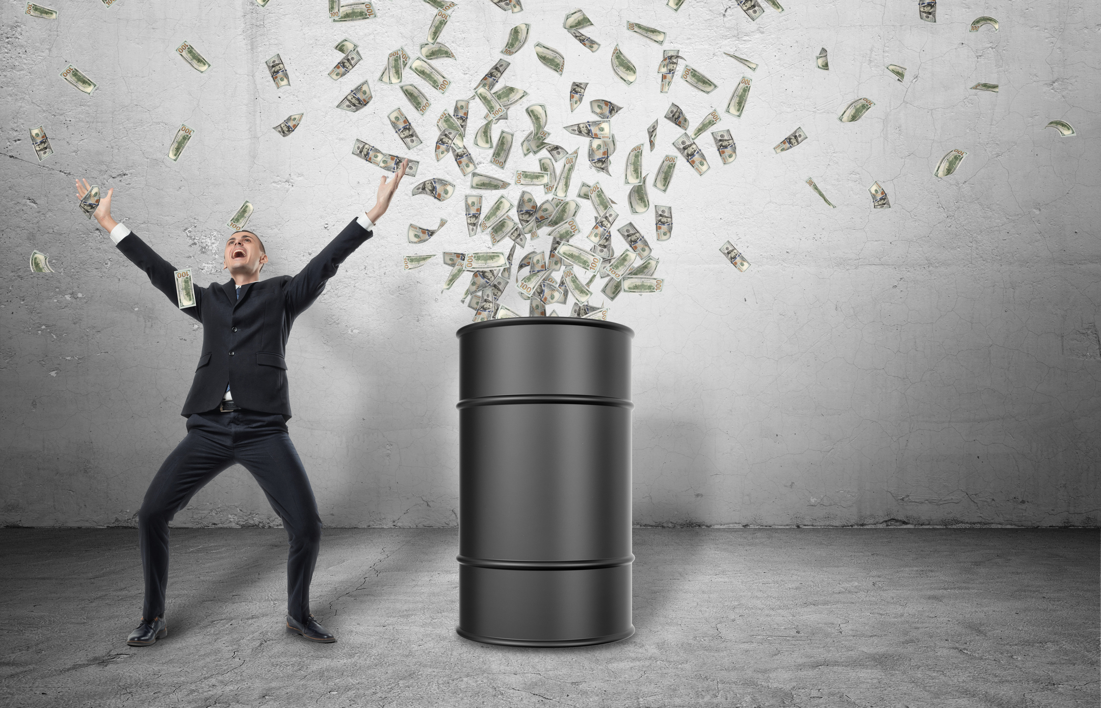 A smiling man stands next to an oil barrel from which paper currency erupts.