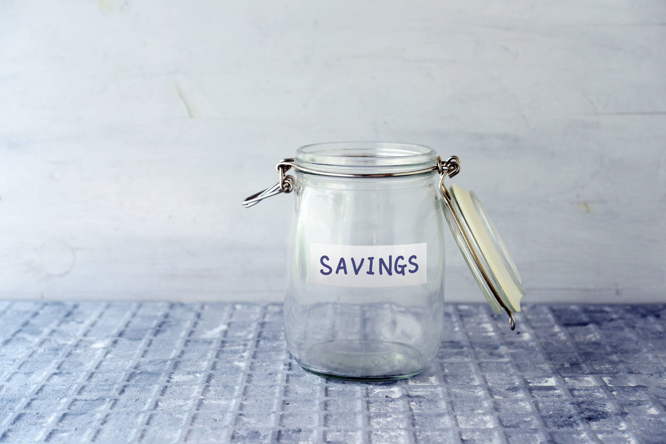 Empty glass jar labeled savings. 