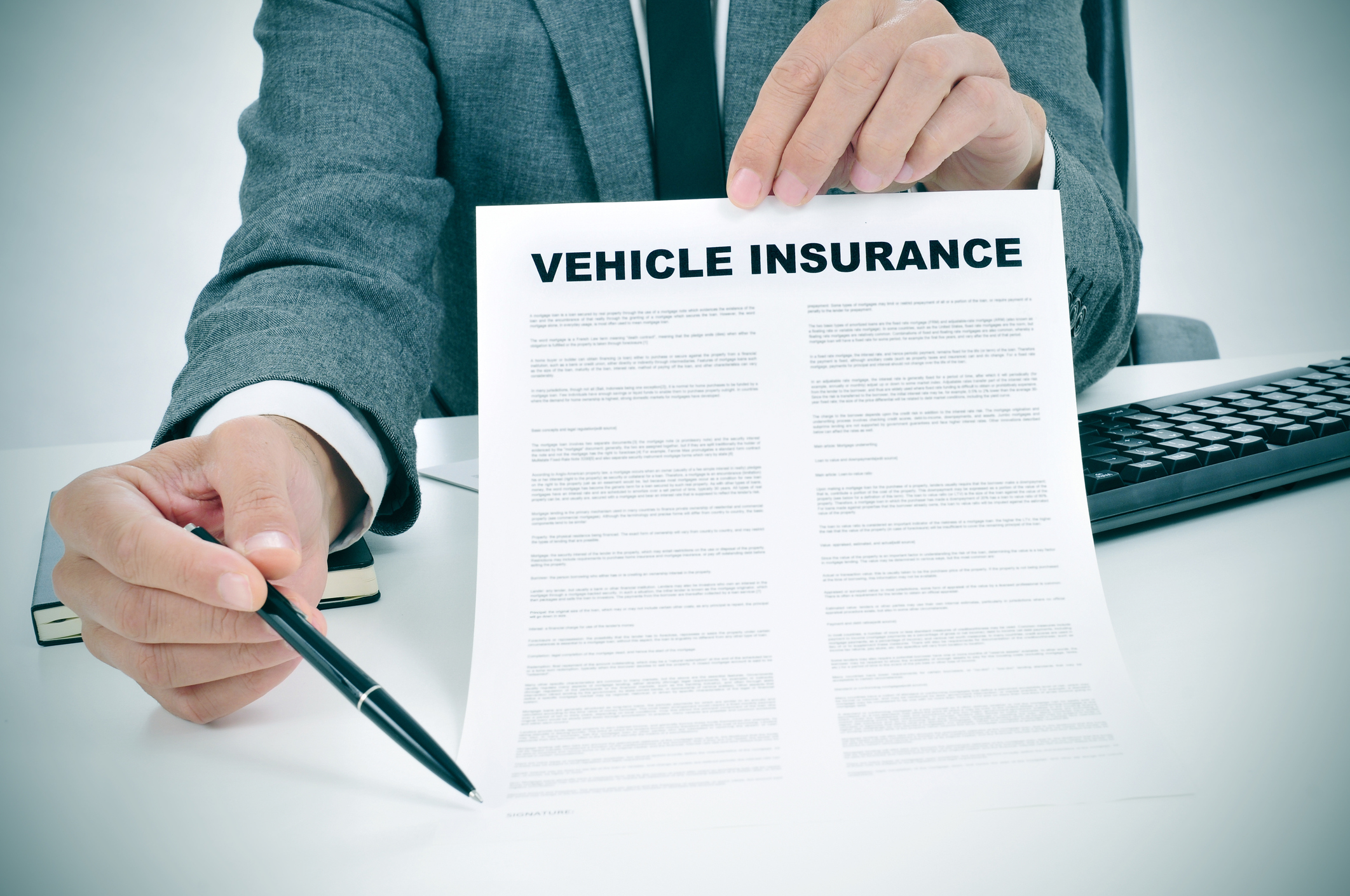 An insurance agent holding a pen and a policy