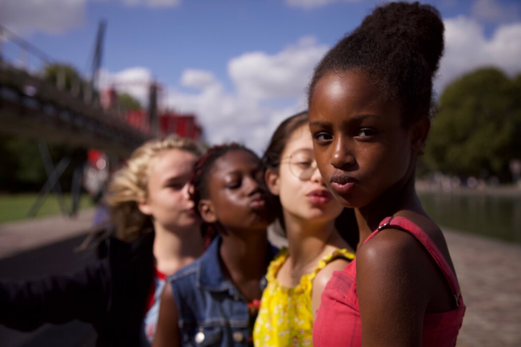 Photo of a group of young girls looking at camera. One of them looks stern.