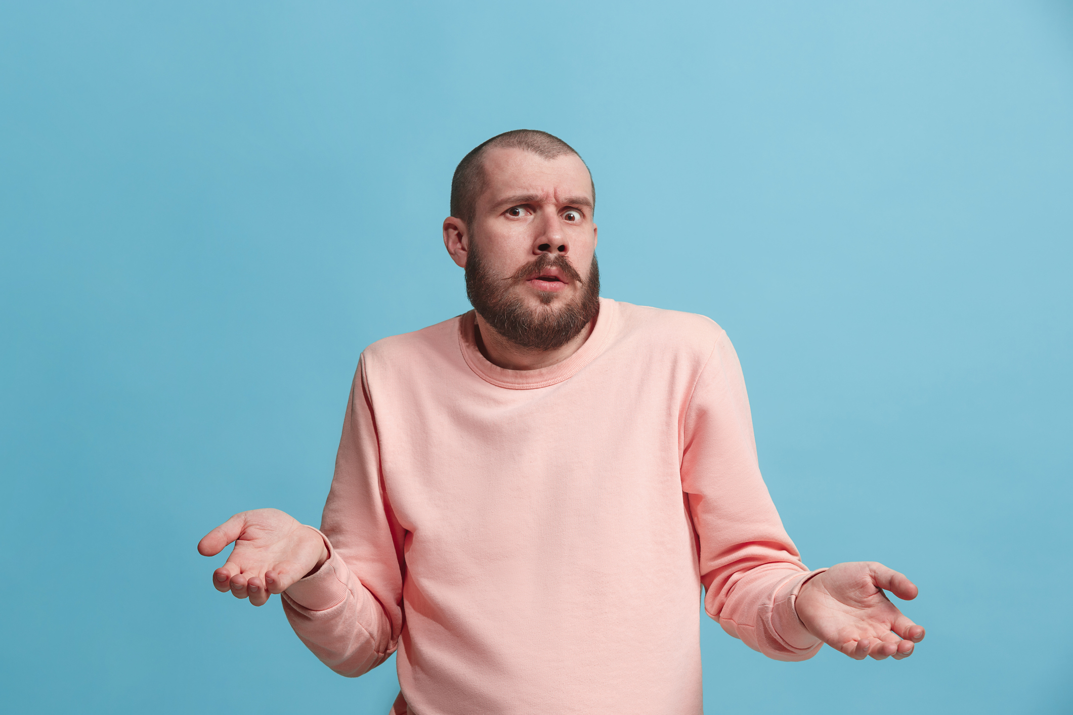 A person in a pink sweatshirt with a confused expression.