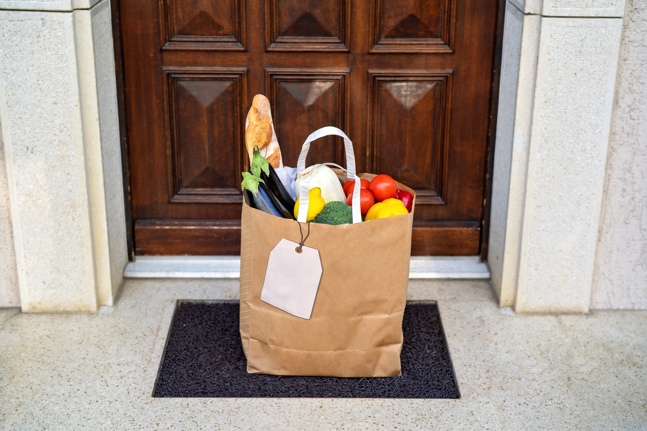 bag of groceries sitting on doormat from delivery service