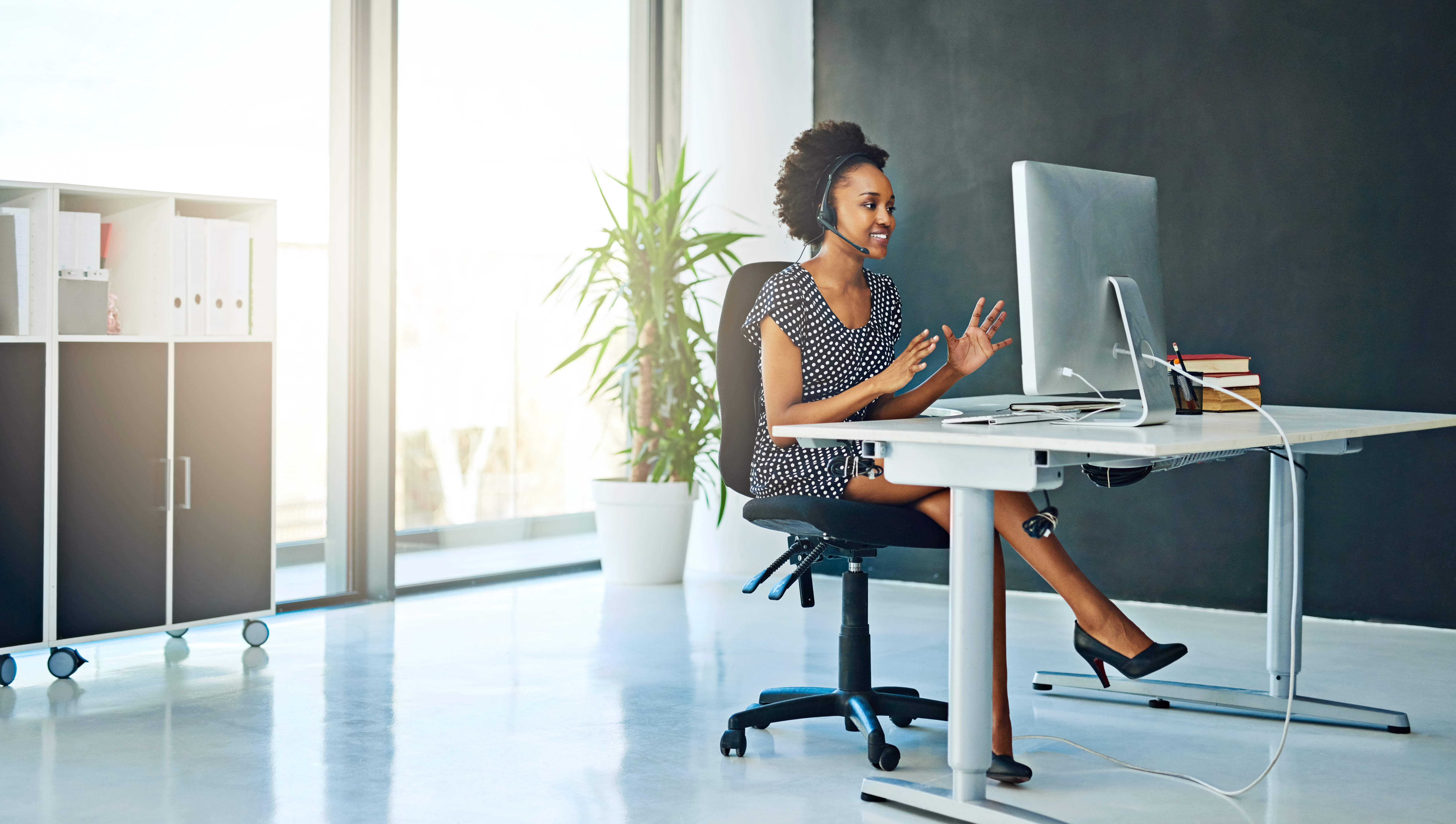A woman uses Zoom's software in an office.
