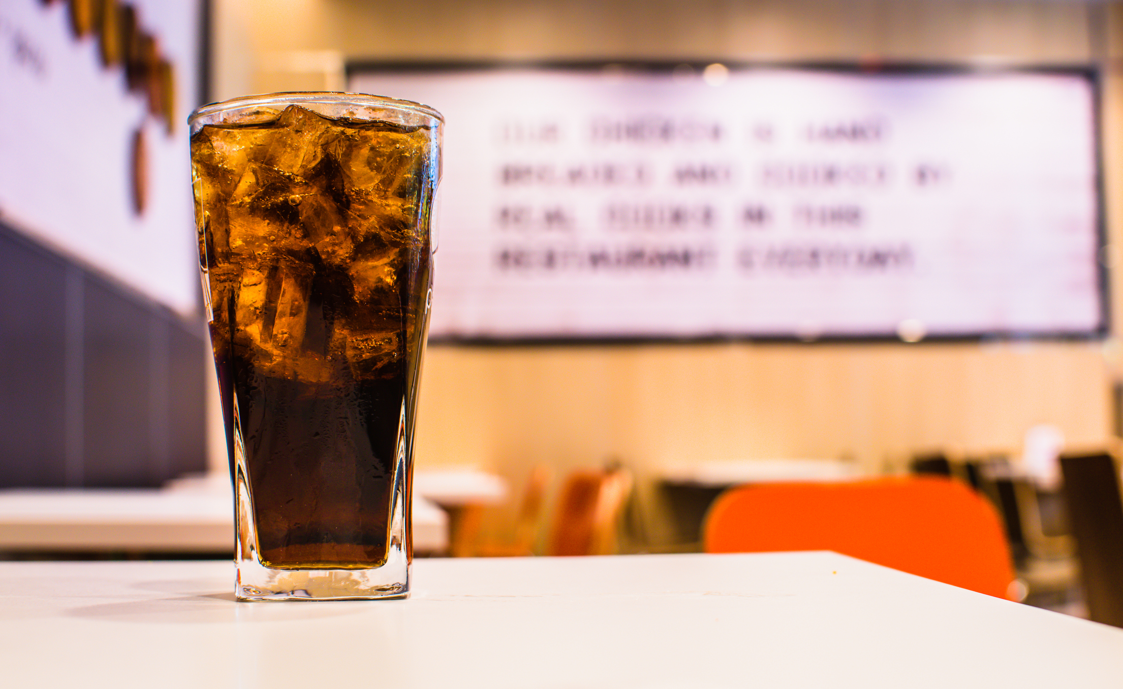 A glass of cola on a diner table.