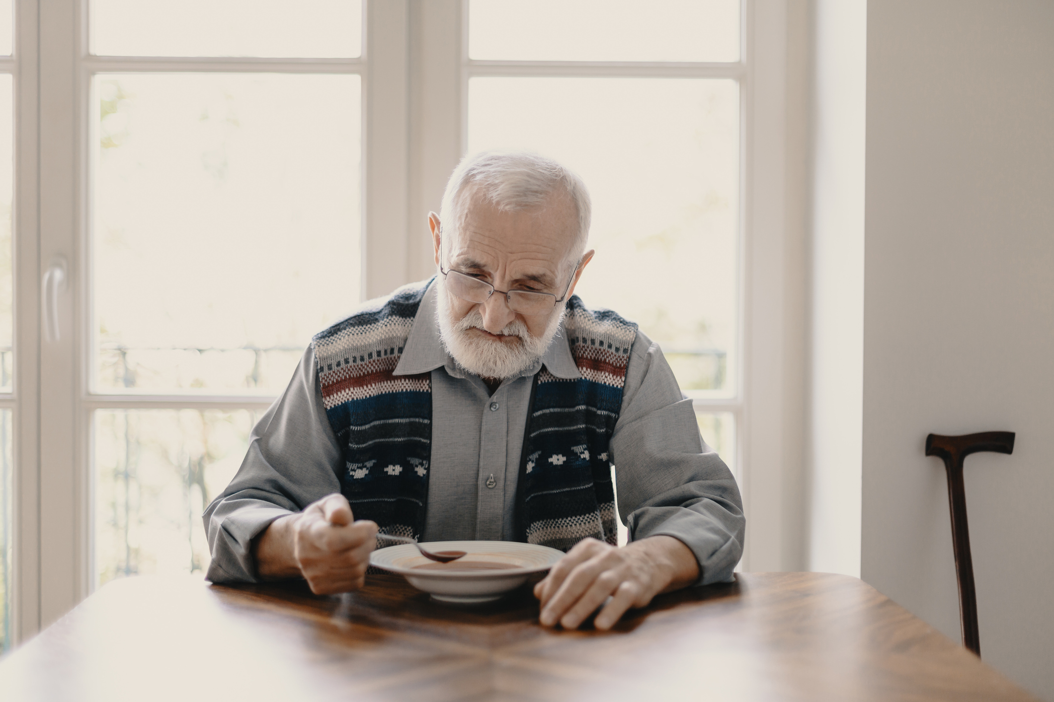 Older man at table eating soup