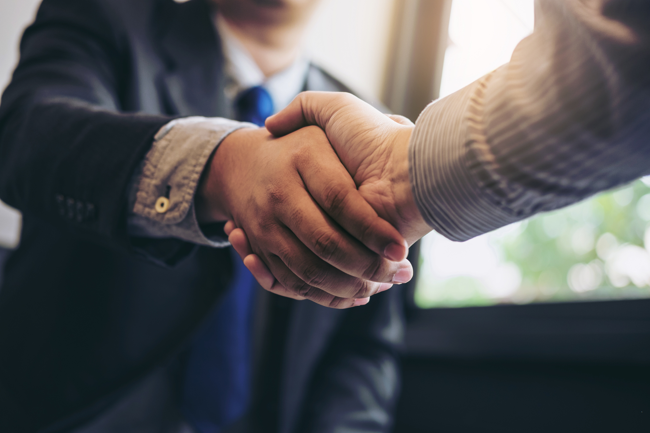 Two men shake hands