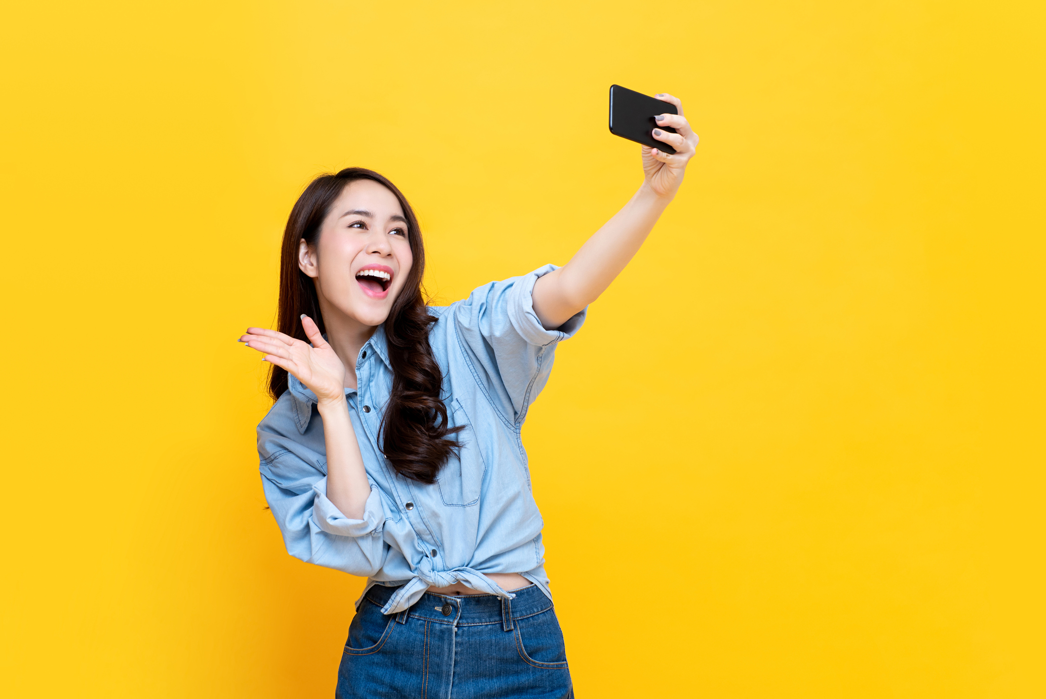 Girl waving to smartphone