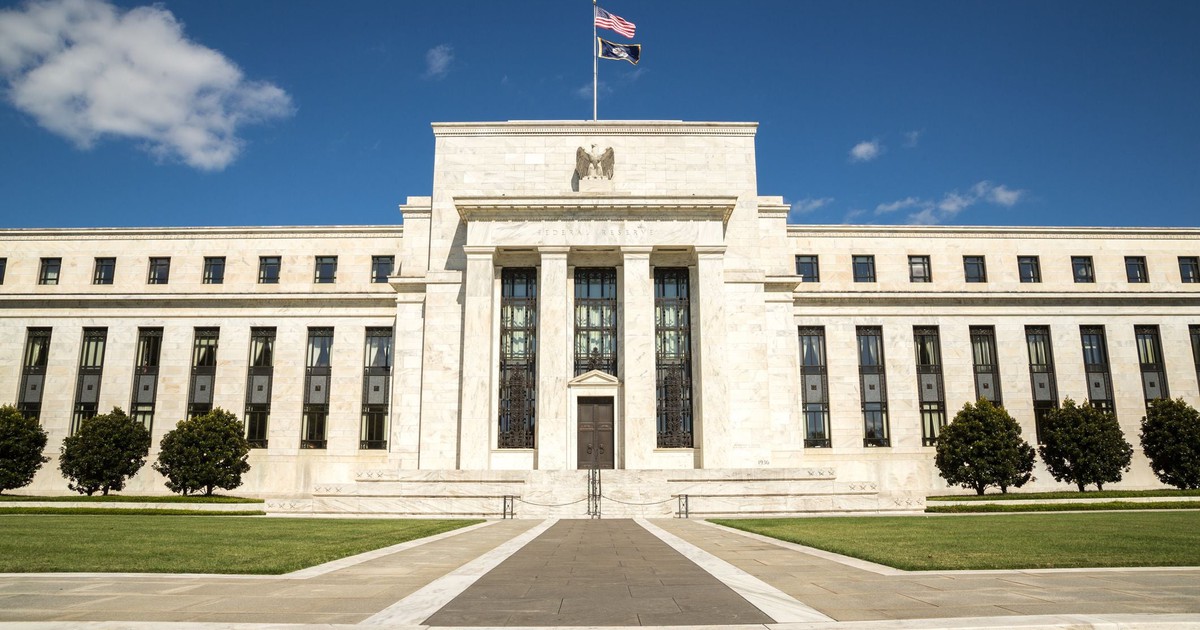 Federal Reserve Building seen from street level, with blue sky above.