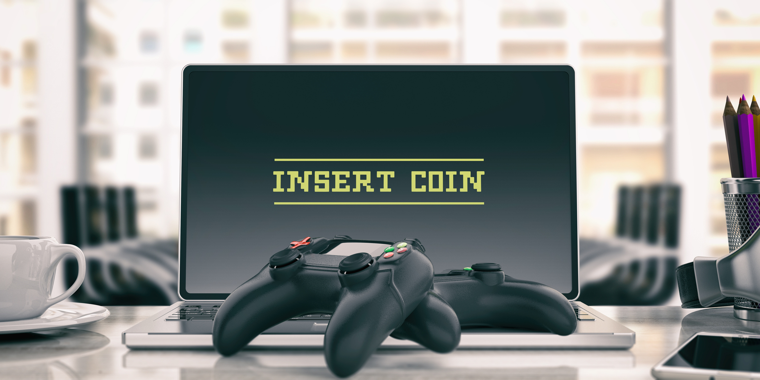 Two game controllers and a laptop with text 'Insert Coin.'