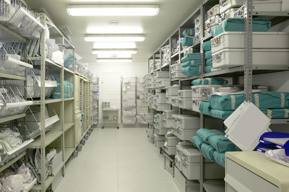 A storeroom of medical supplies in bins stacked floor to ceiling.