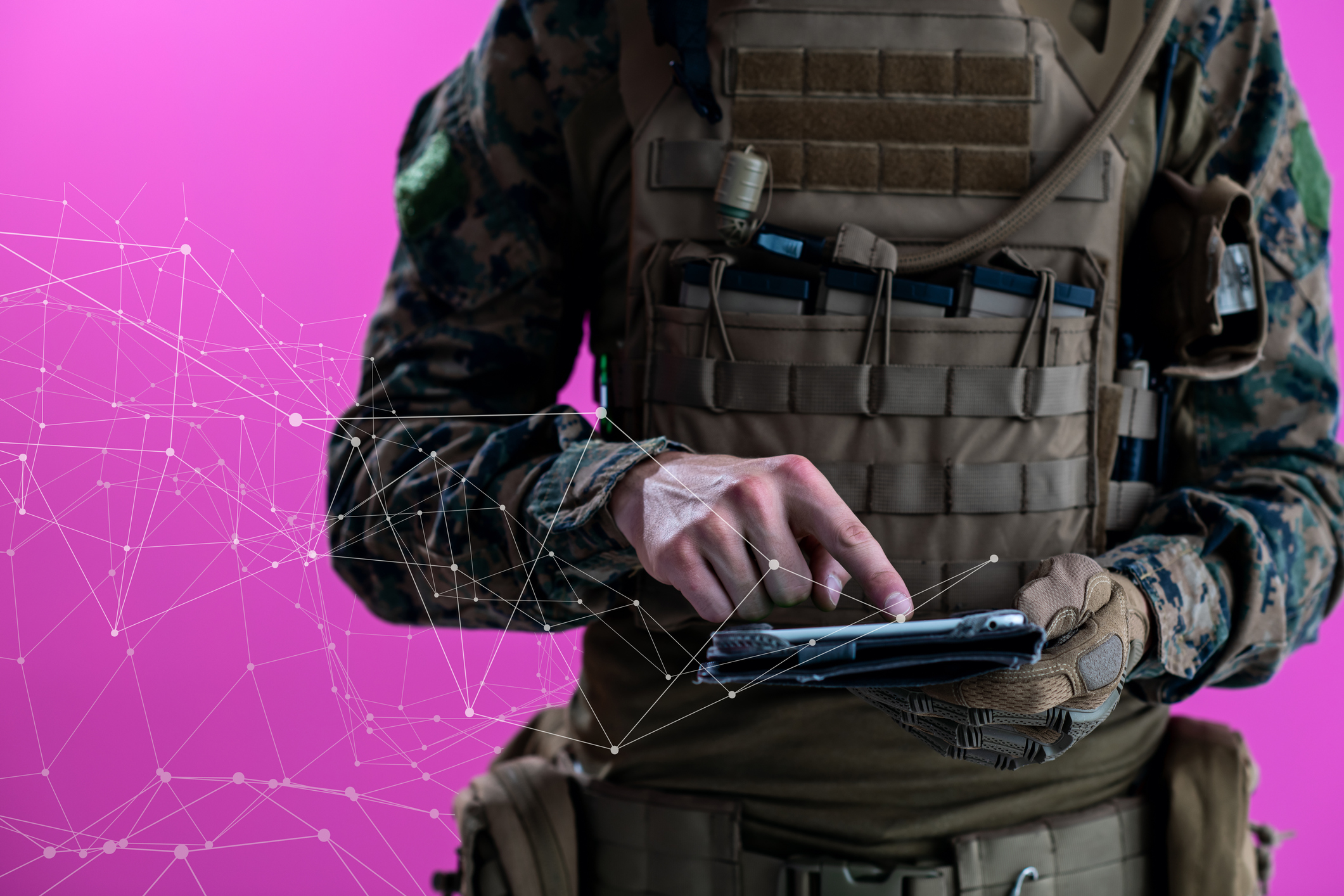 A soldier checks data on a tablet.