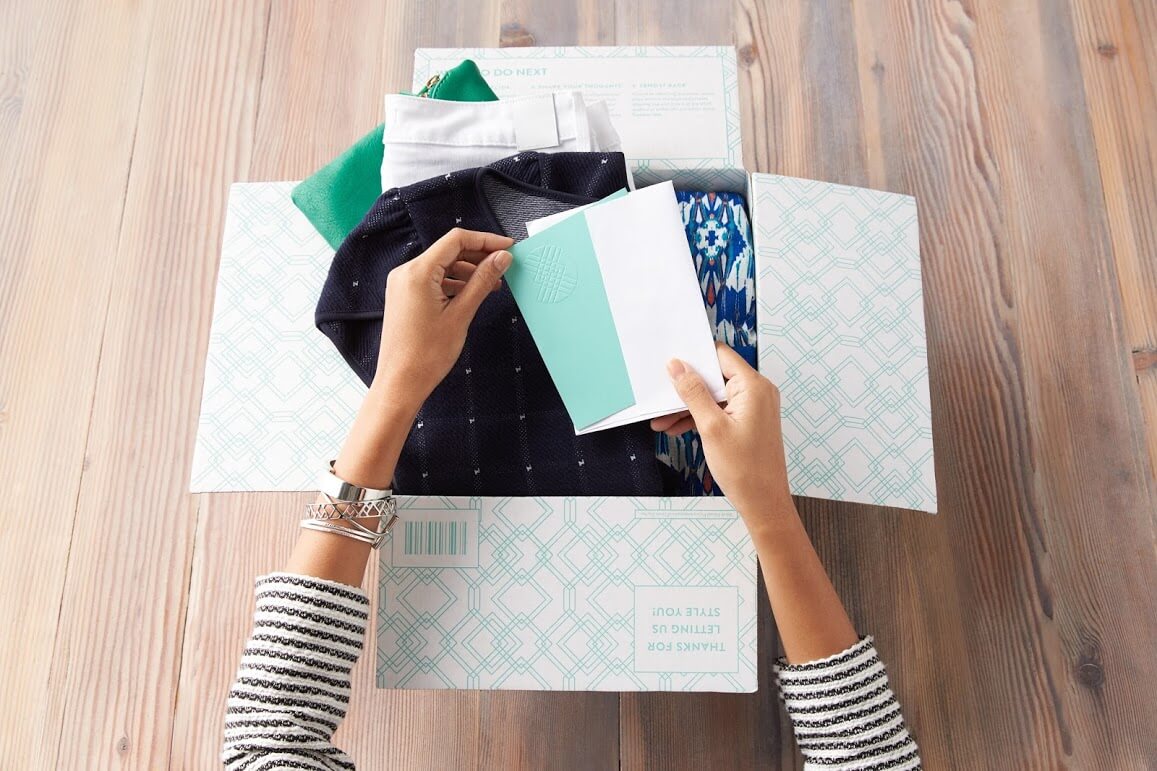A woman unboxing a Stitch Fix order.