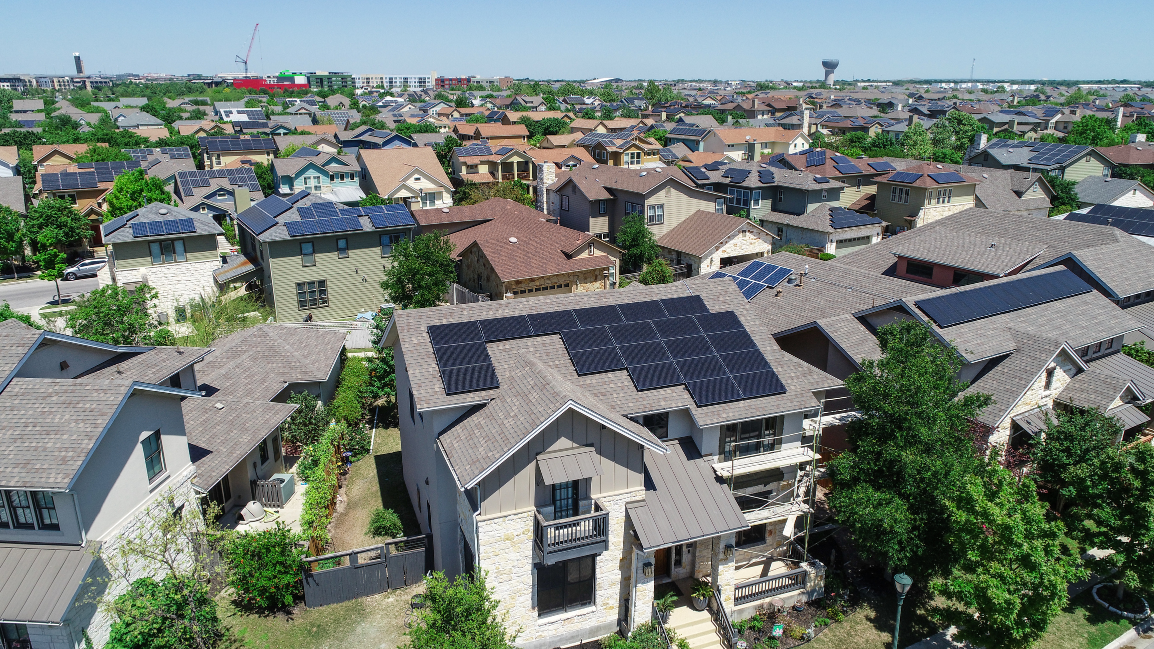 Aerial view of neighborhood with solar panels on many roofs.
