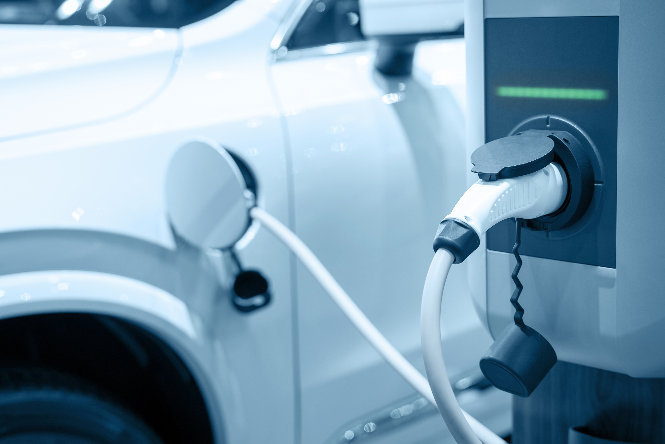 An electric vehicle recharges at a charging station