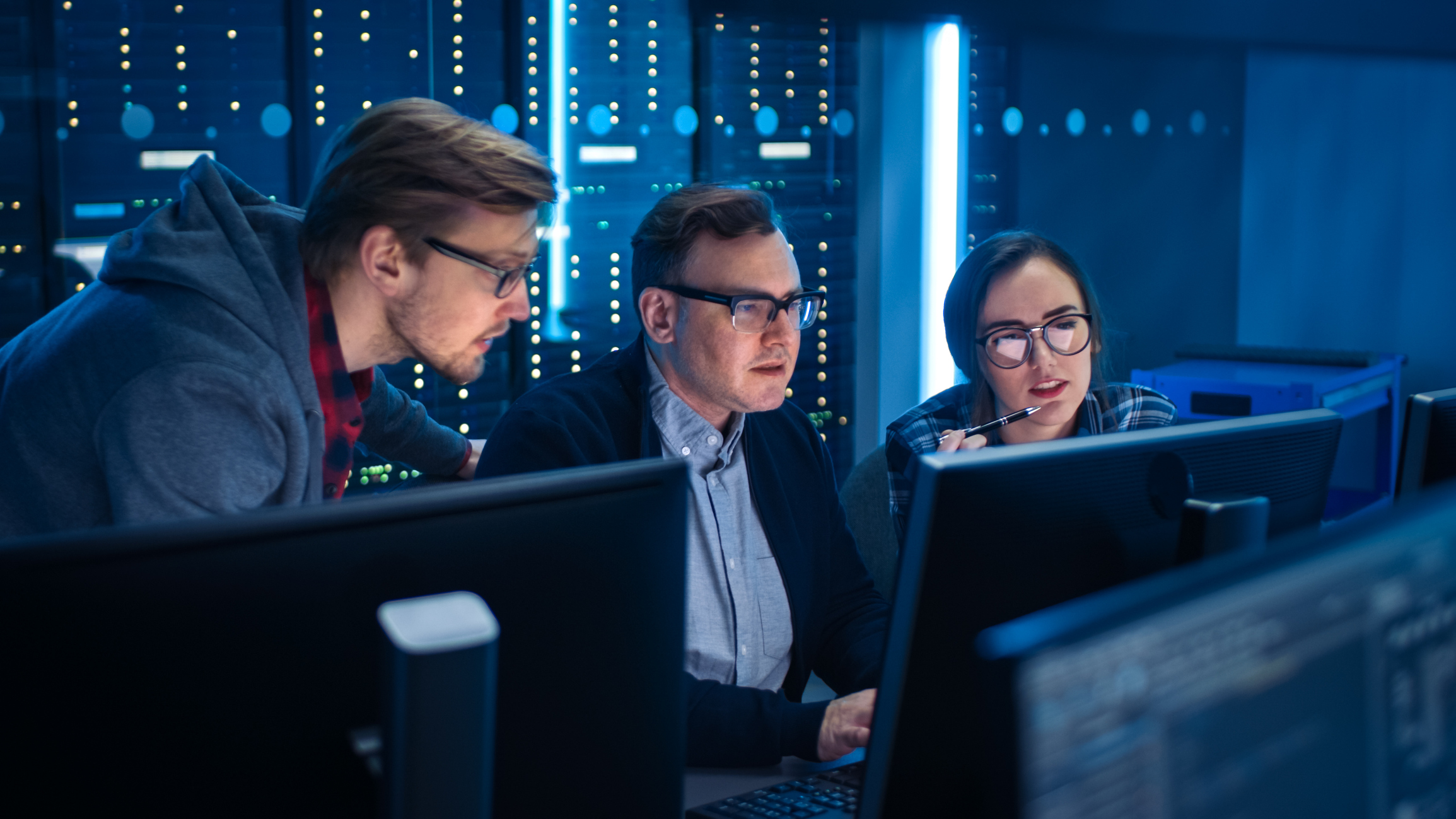 A group of IT professionals checks a computer.