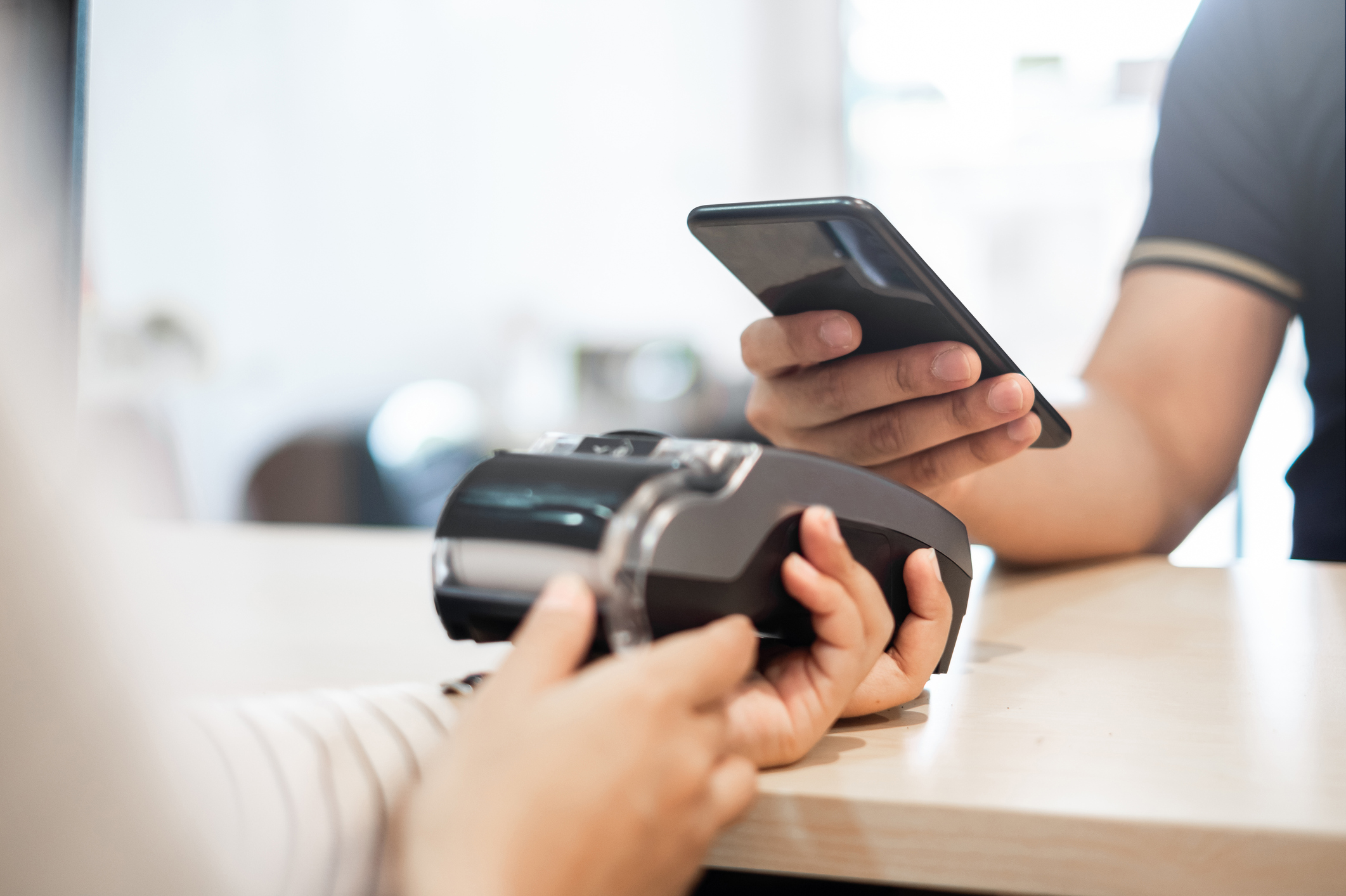 A person using a smartphone at a counter.