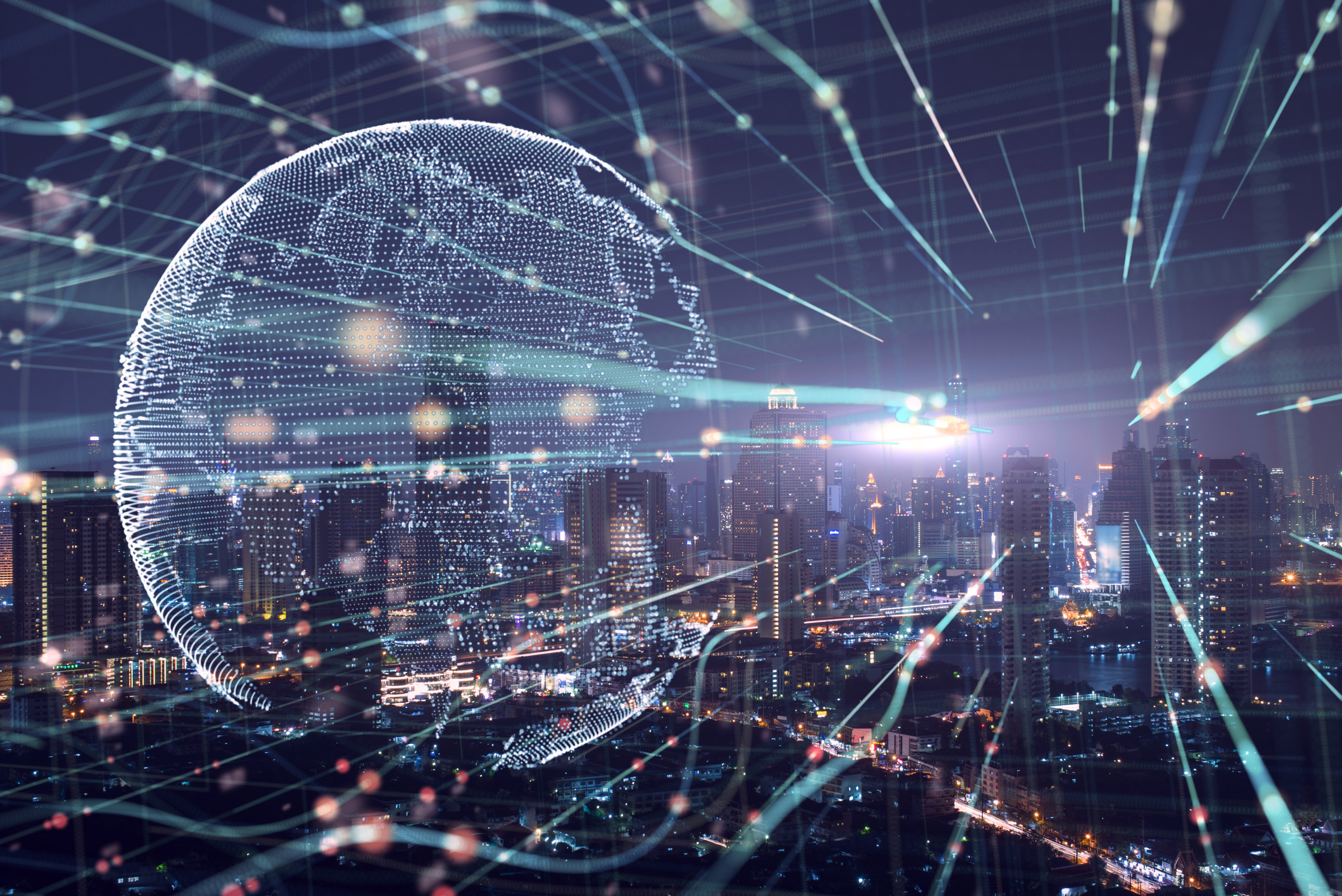 A digital globe overlaid across a downtown city landscape at night.