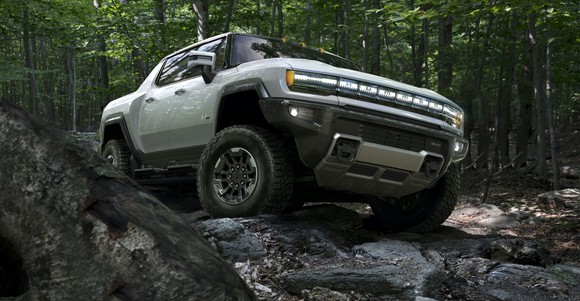 A silver GMC Hummer EV, shown on a rocky trail.
