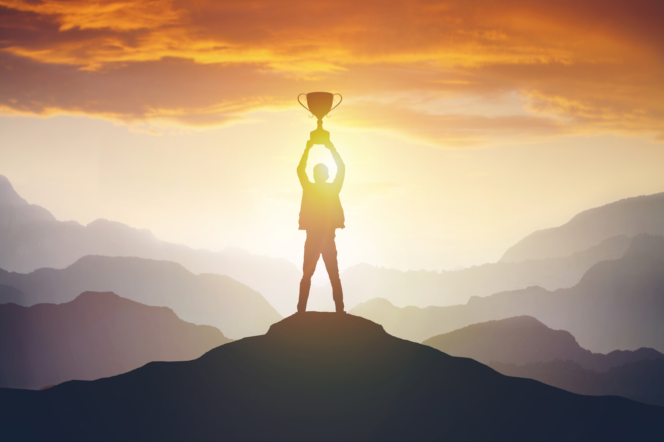 Person holding up trophy on hill