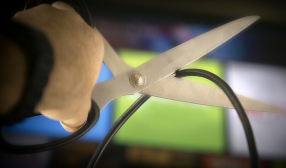Scissors about to cut a cable cord.