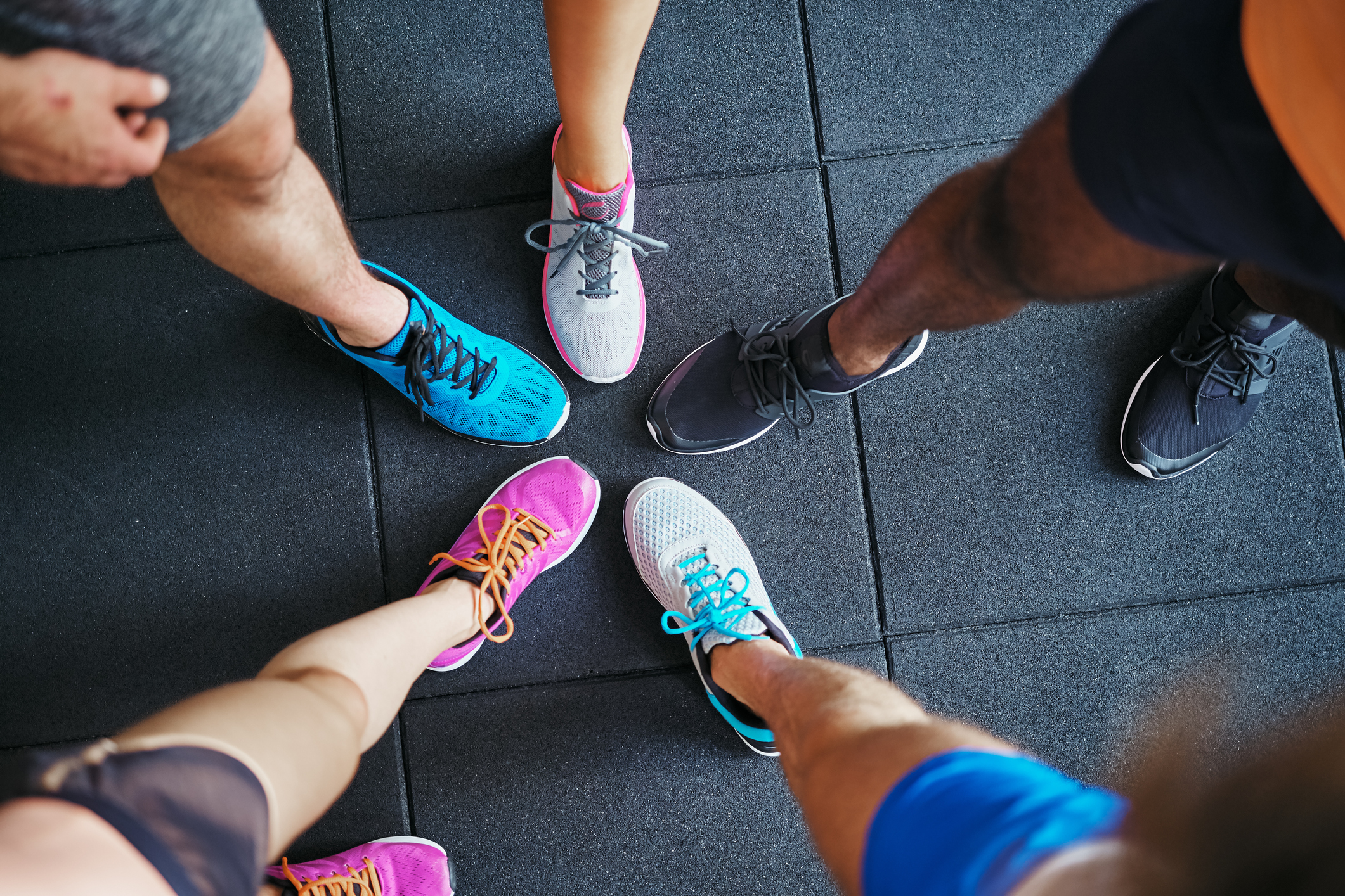 Five people putting their sneaker-clad feet together.
