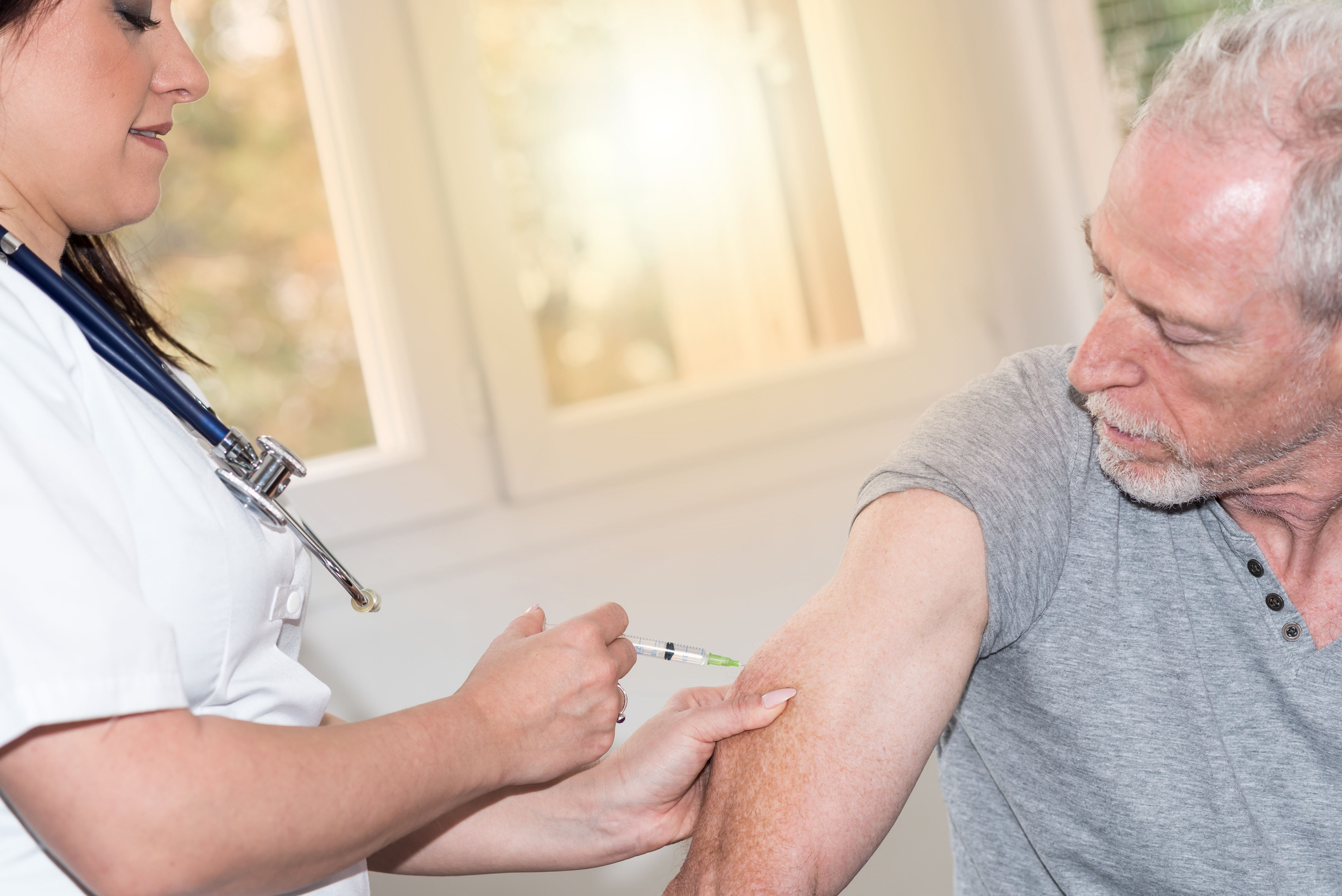 Nurse injecting older man_GettyImages-895675022