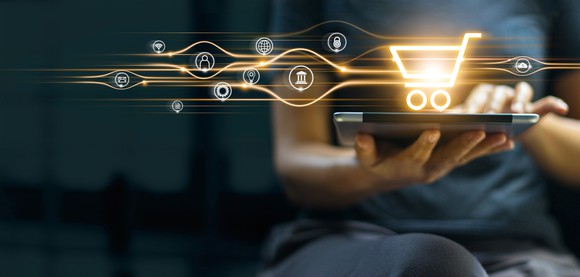 A digital shopping cart projected from a tablet symbolizes the growing e-commerce market.