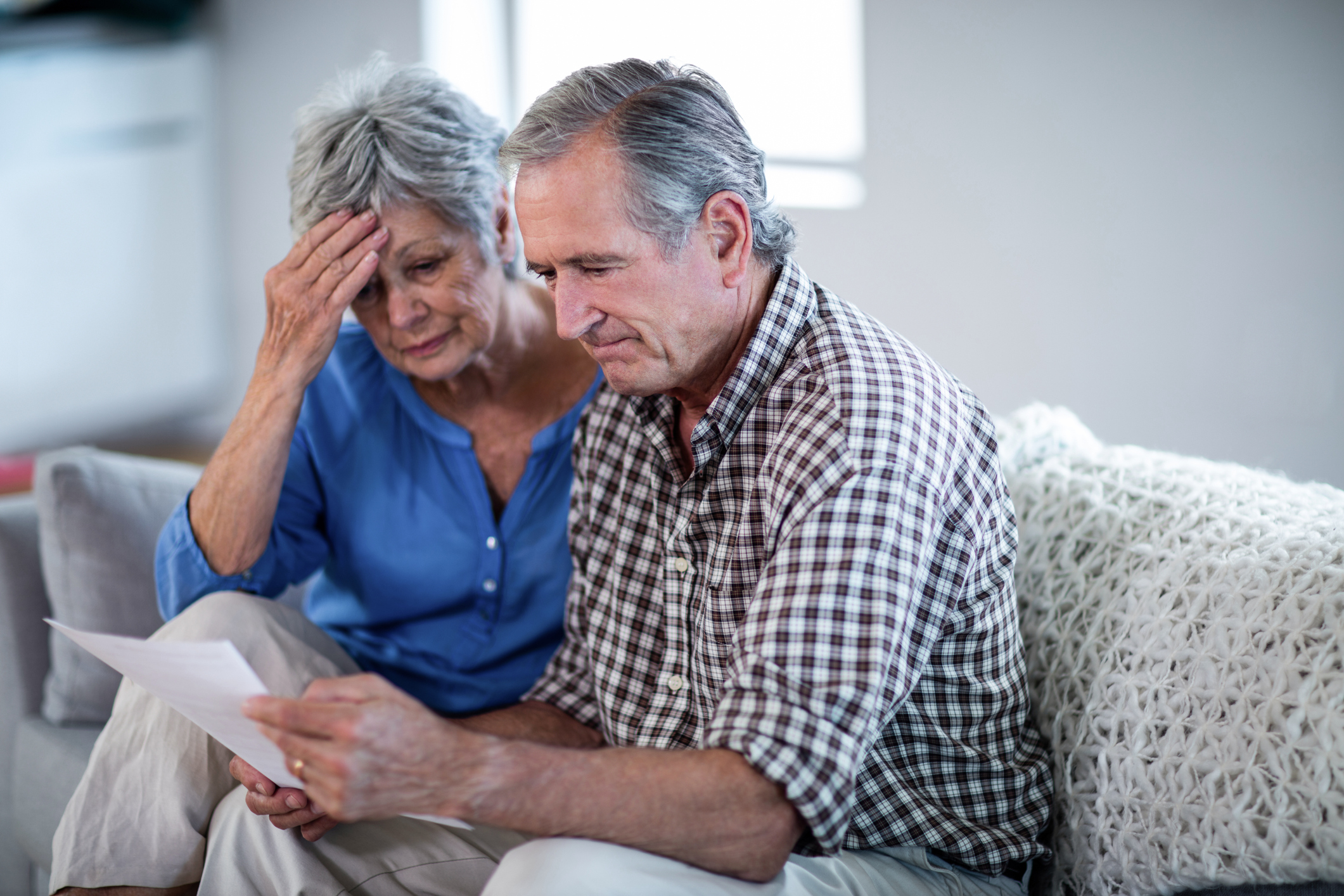 Older man and woman looking at document with concerned expressions