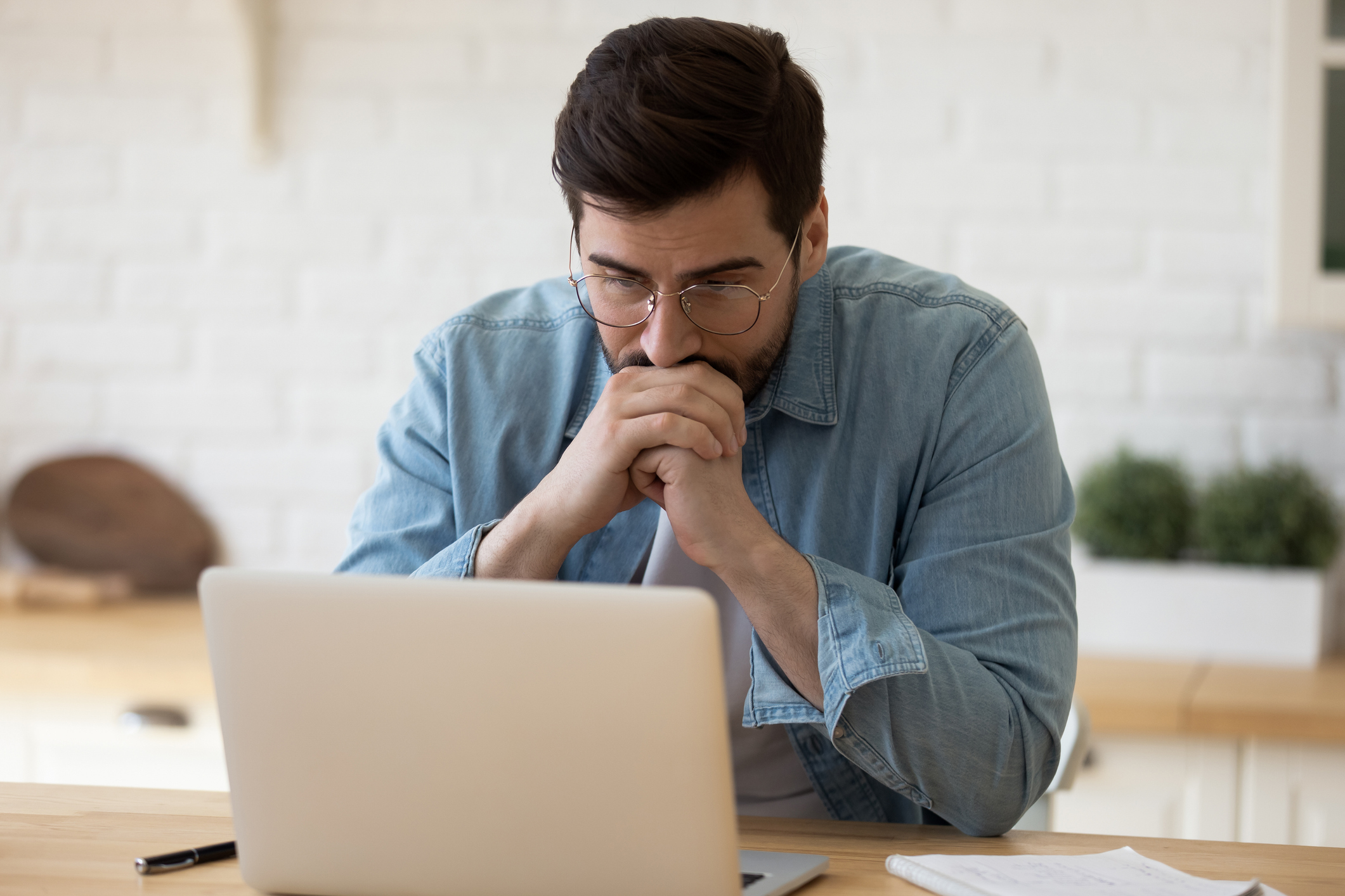 Man at laptop with serious expression