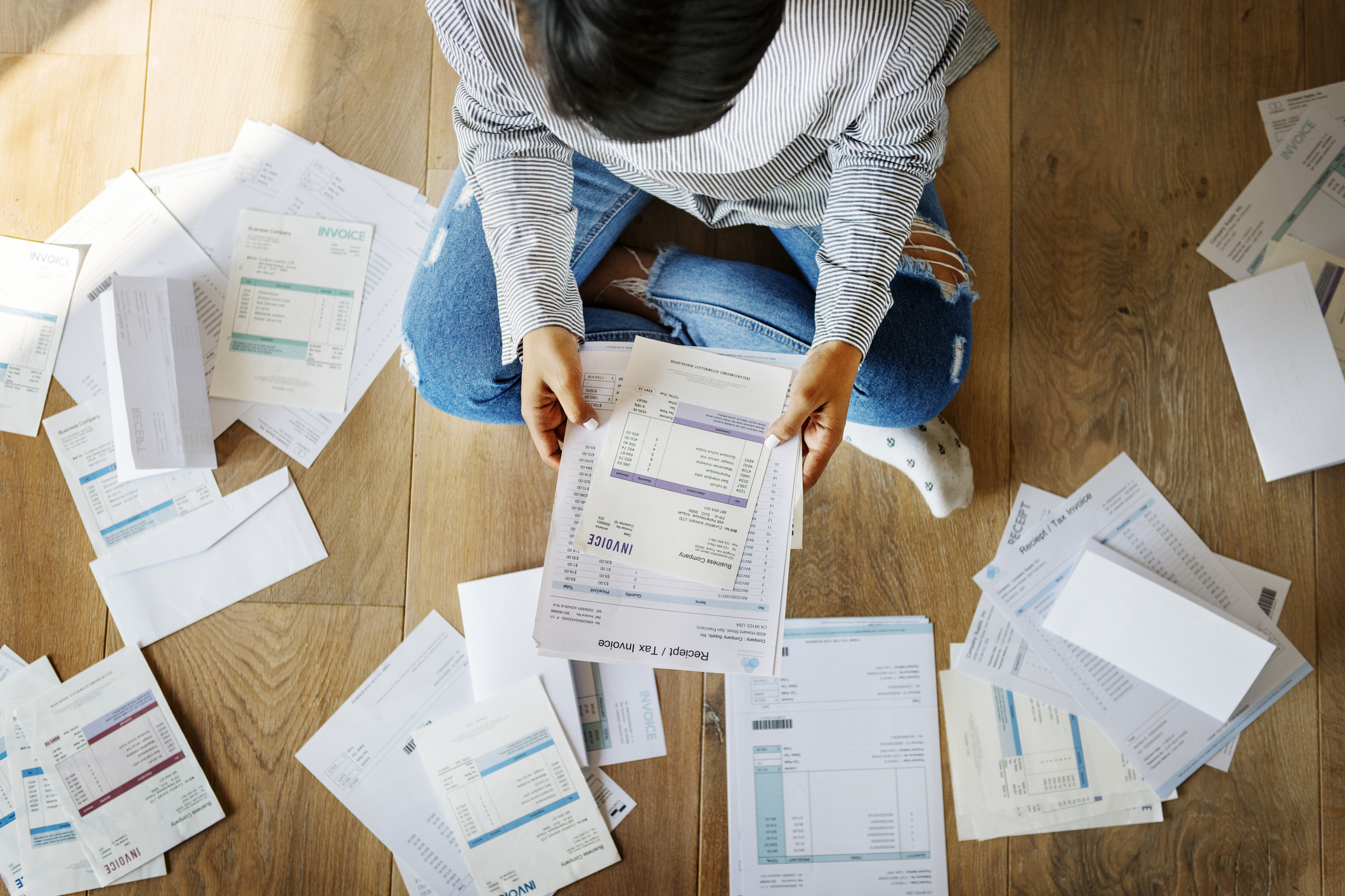 Man surrounded by a pile of bills.