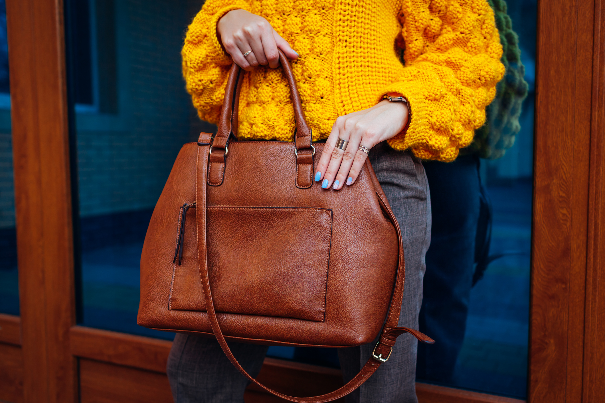 Lady wearing yellow sweater and holding large handbag