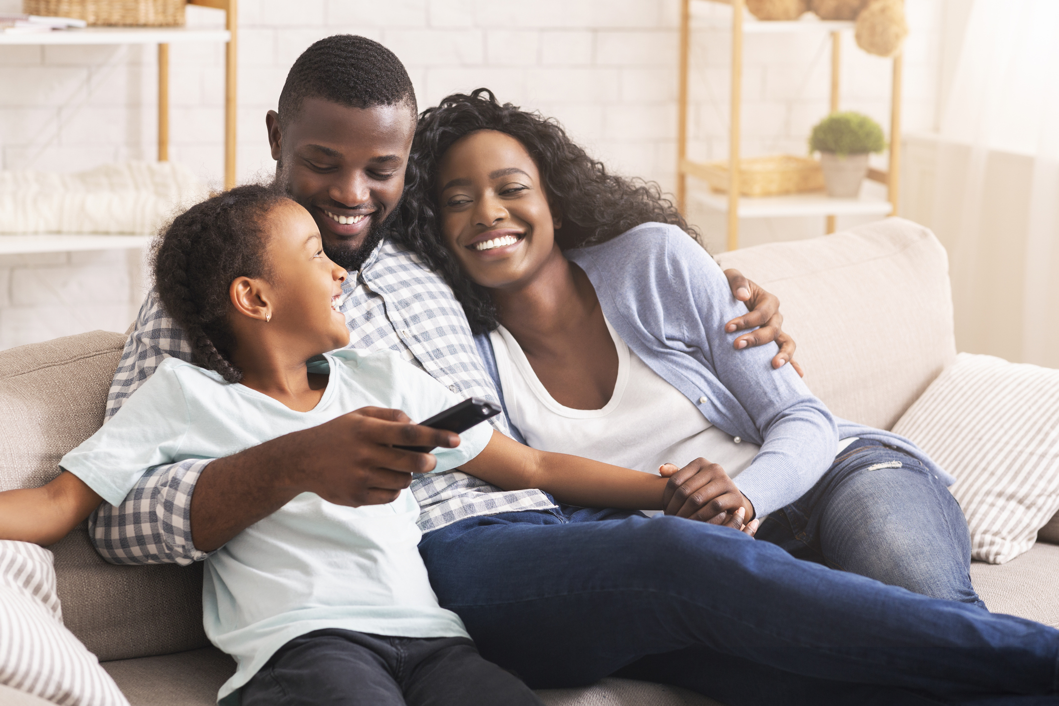 family on couch smiling, watching TV