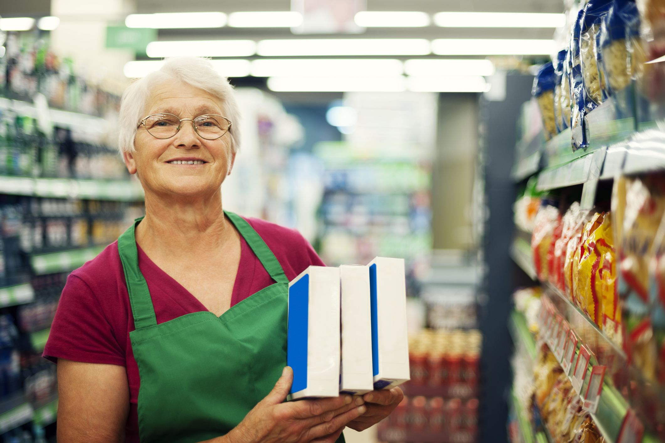 Older woman working stocking shelves.