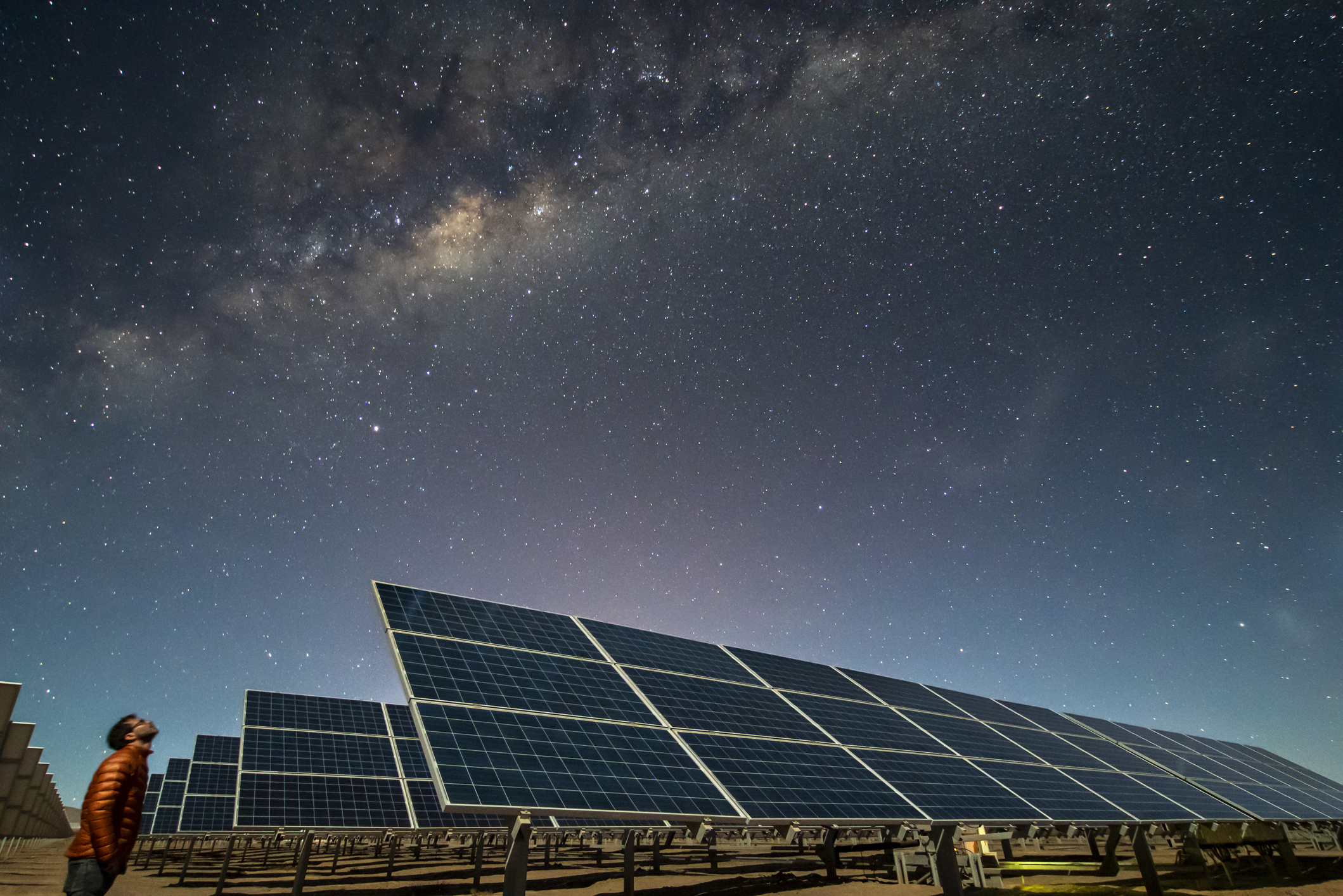Solar panels under a starry night sky.