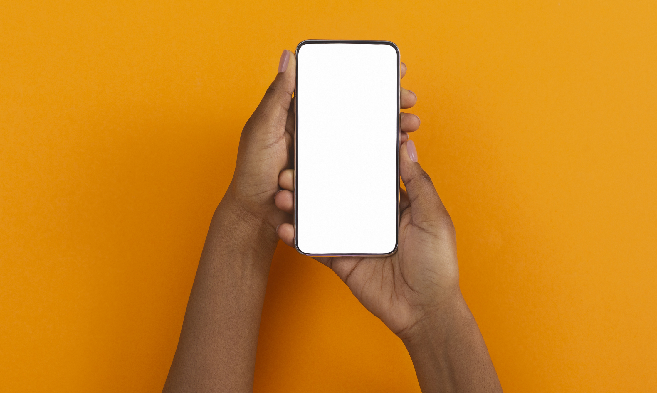 Two hands hold a smartphone with a blank screen.