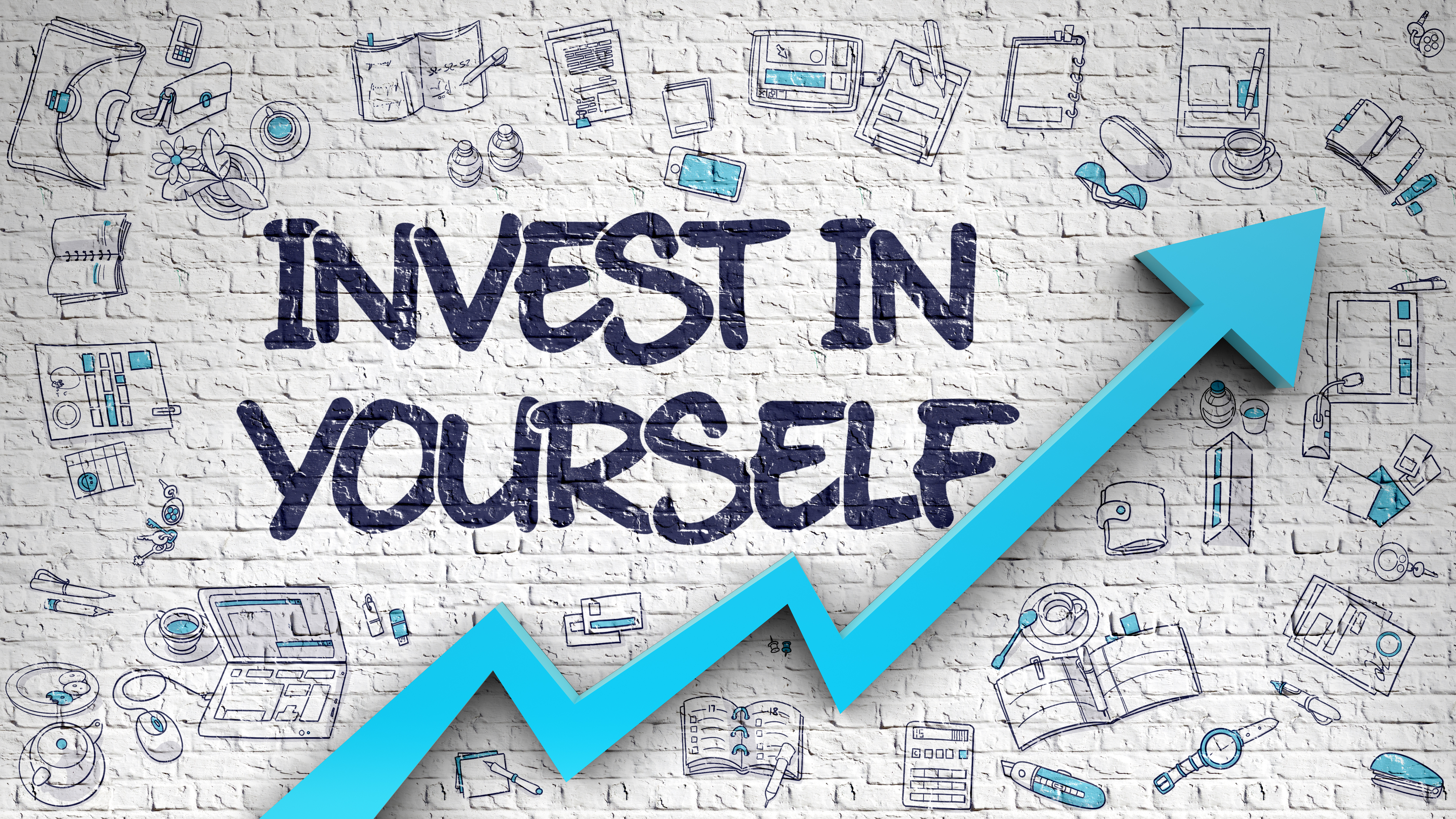 The words "Invest in Yourself" written on a brick wall with an upward trending blue arrow underneath.