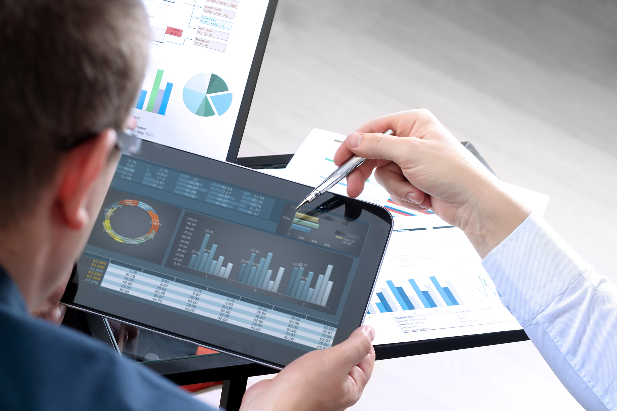 A person looking at charts on a tablet.
