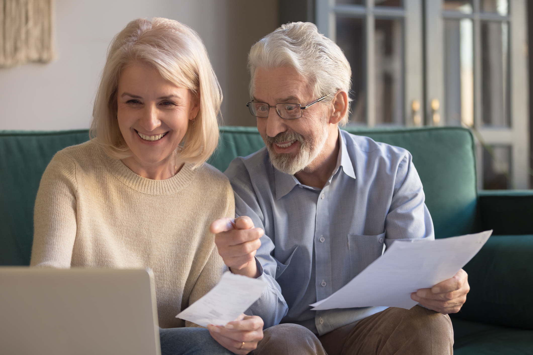 Smiling older man and woman at laptop