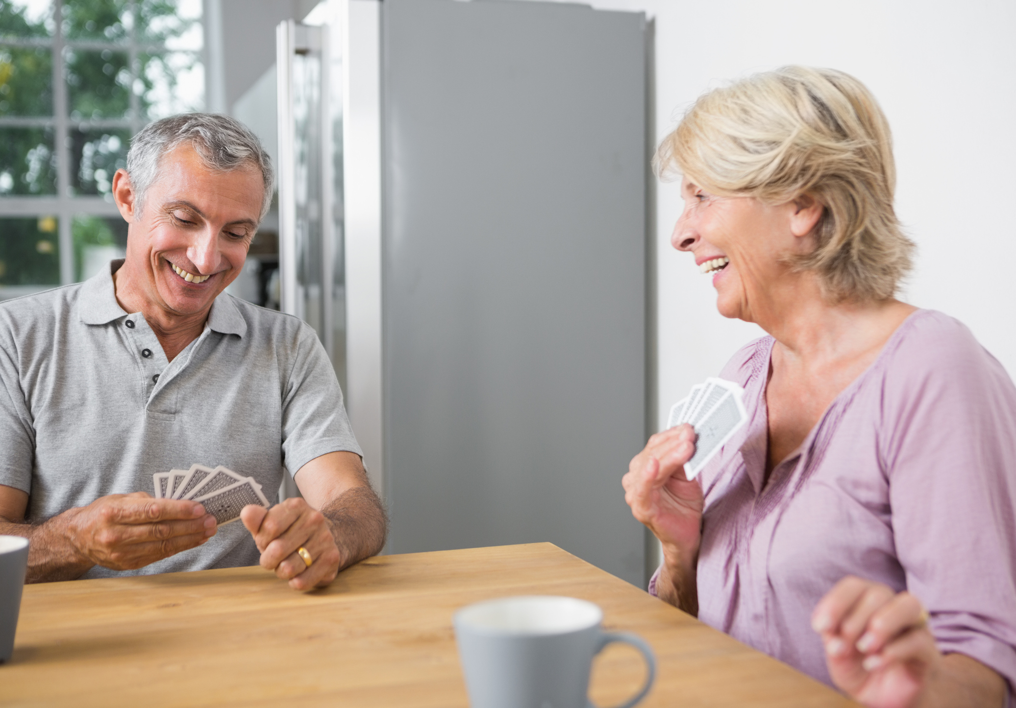 Smiling older man and woman playing cards
