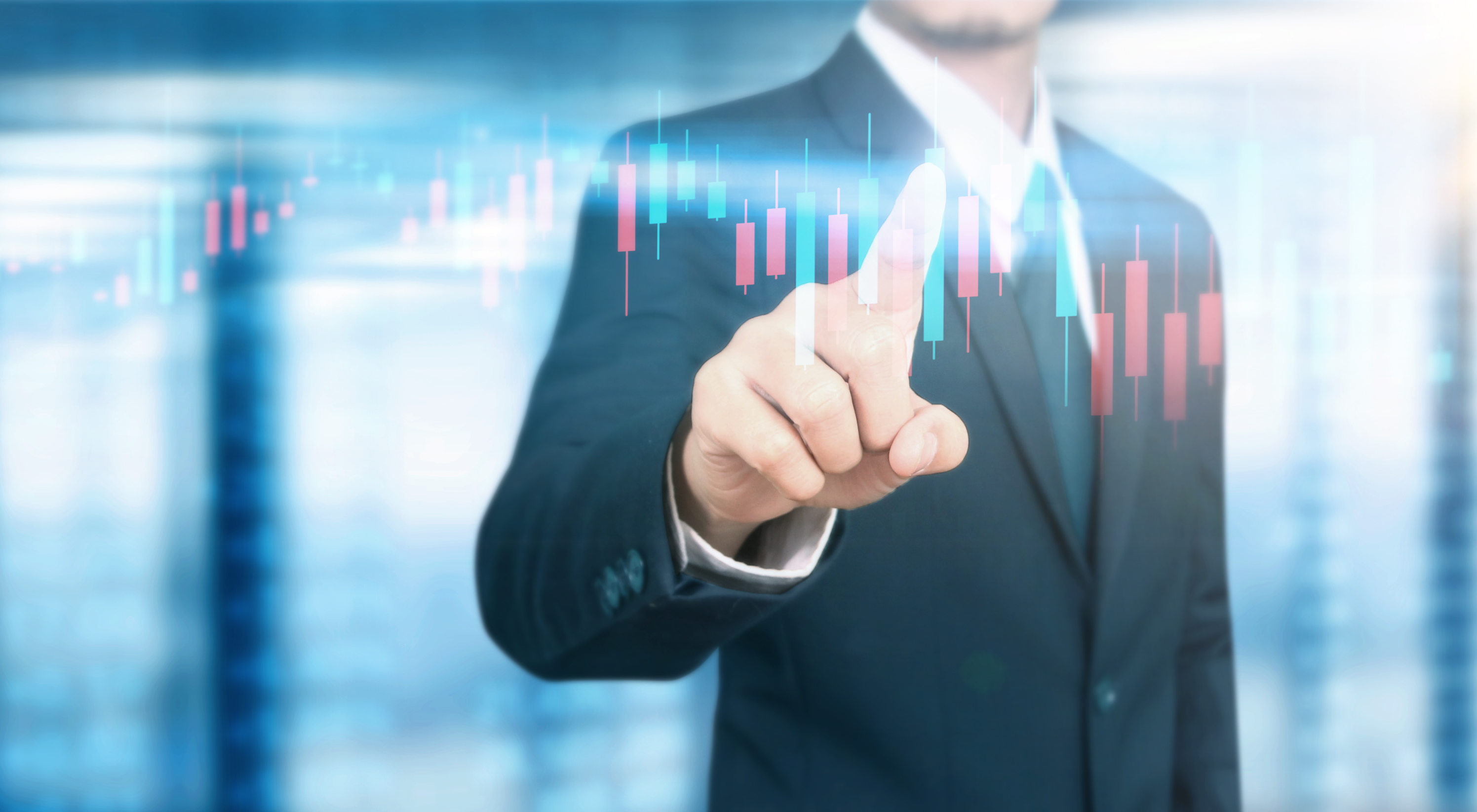 A man in a suit touching a digital stock chart.