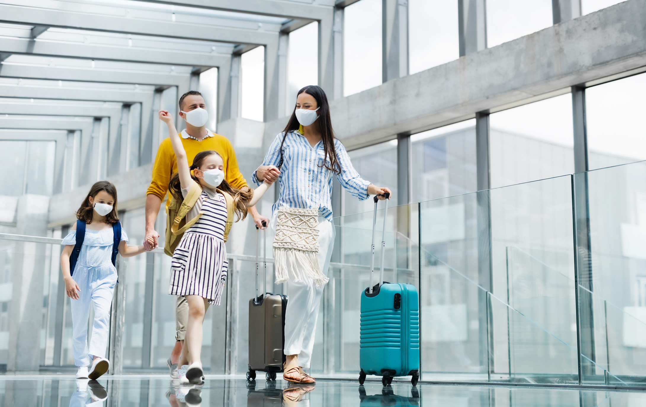 A family at an airport with masks on.