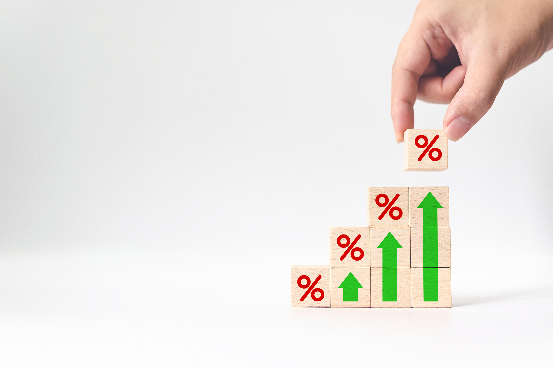 Stacked wooden blocks showing vertical arrows growing larger with percent blocks capping each column