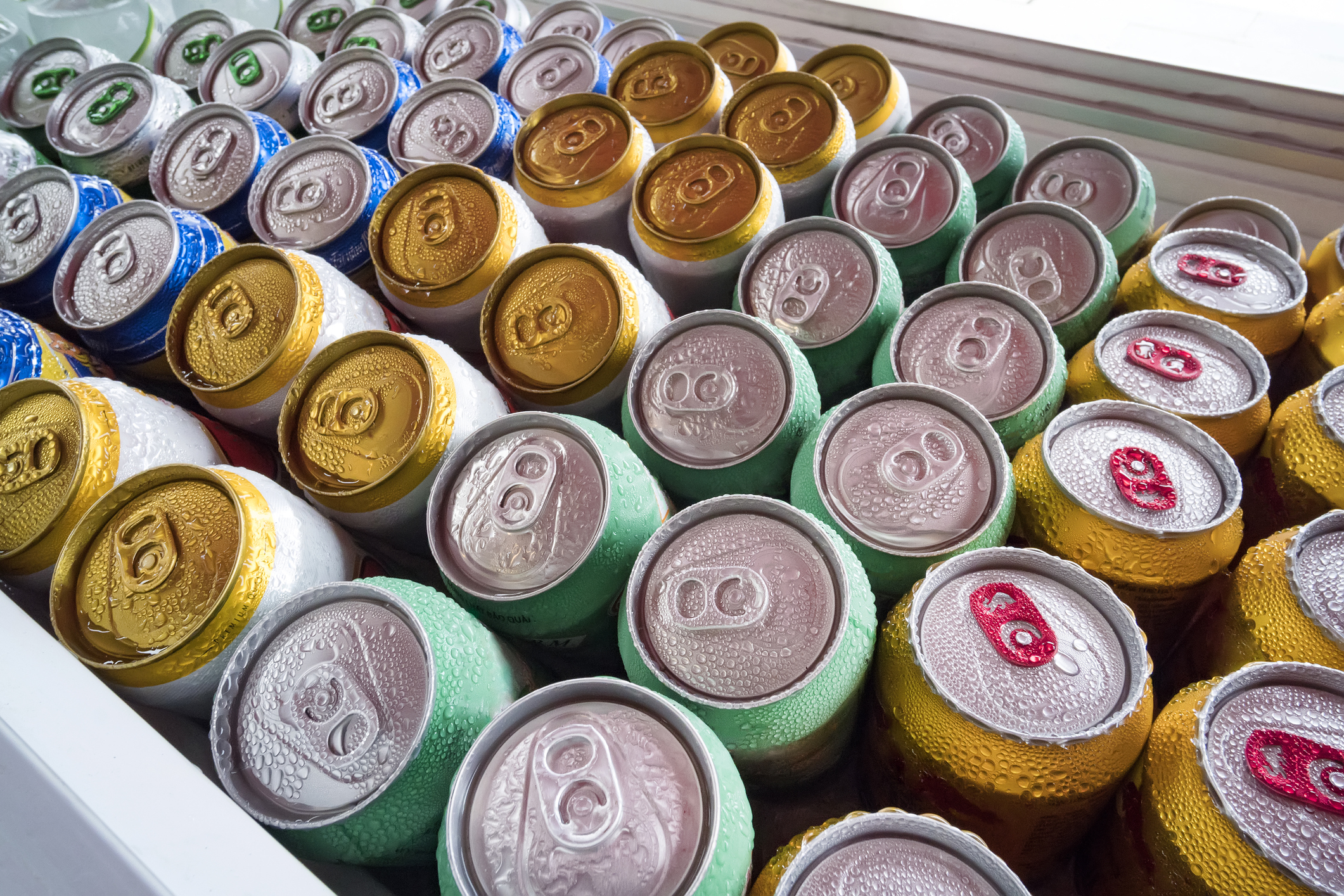 Chilled cans of hard seltzers lying in a cooler.