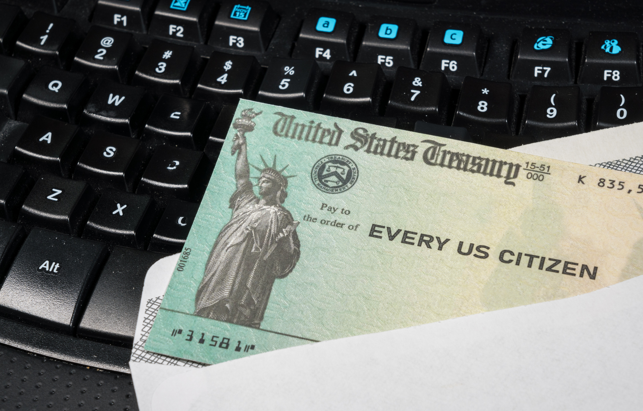 Government-issued check lying on a computer keyboard.