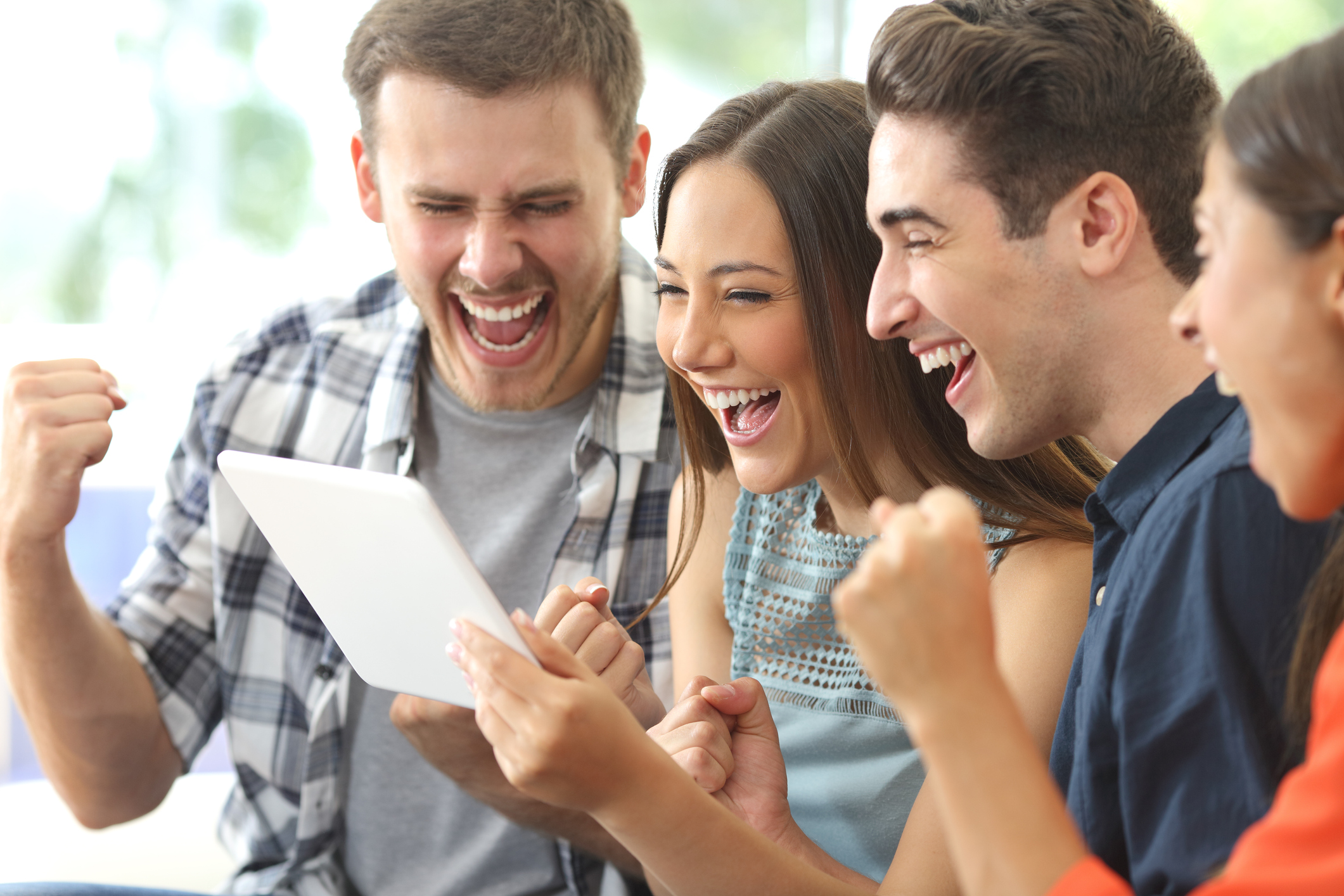 A group of enthusiastic people watching a sports game on a tablet.