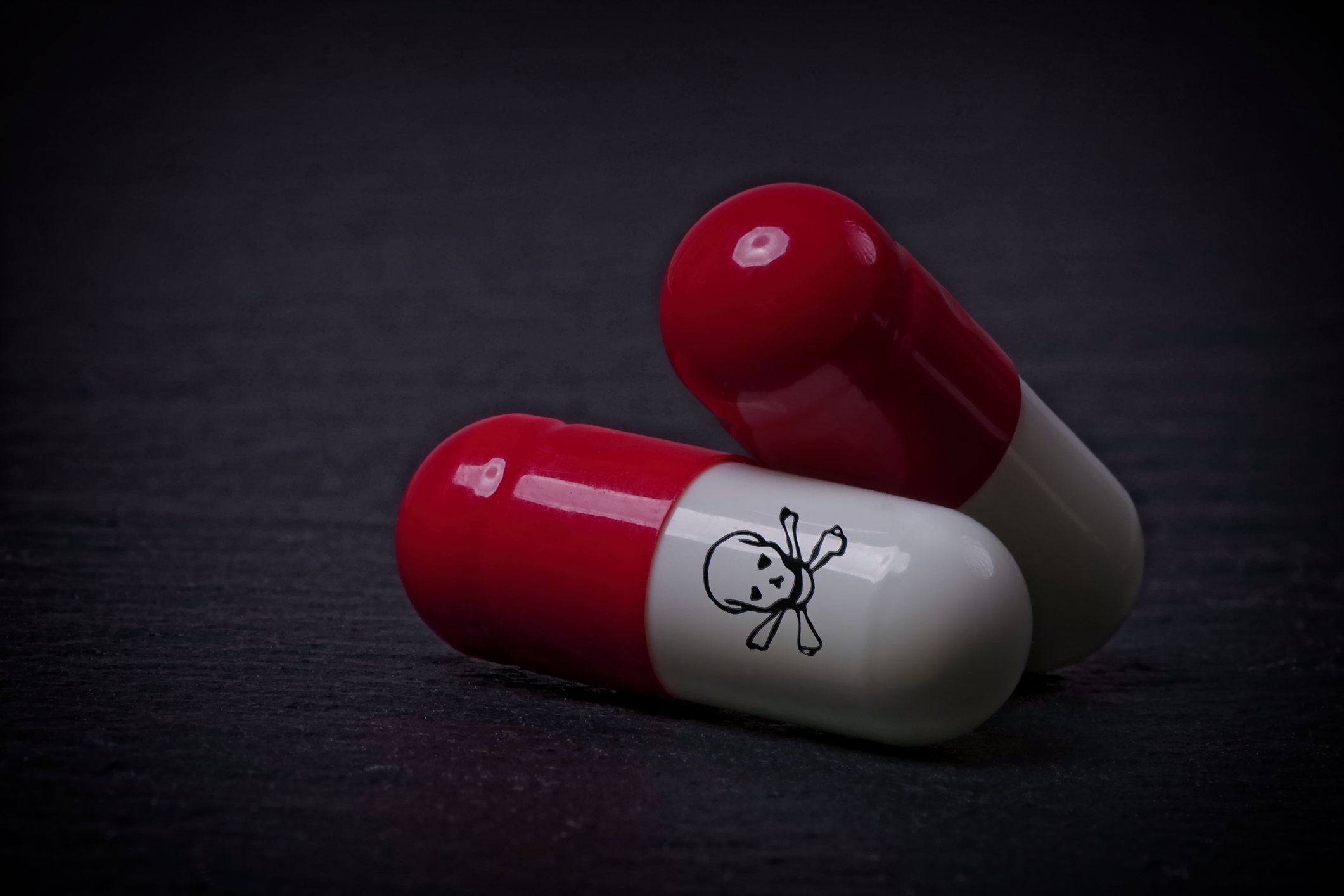 Two pill capsules marked with a skull and crossbones.