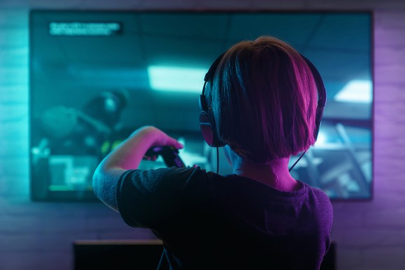 A child with headphones on playing a video game.